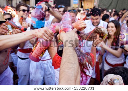 PAMPLONA, SPAIN - JULY 6: People poured over other wine at opening of San Fermin festival. Plaza Consistorial in front of municipality. Pamplona, Navarra, Spain July 6, 2013