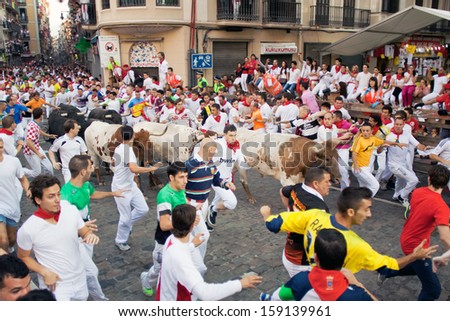 PAMPLONA, SPAIN-JULY 10: People run from bulls on street during San Fermin festival in Pamplona, Spain on July 10, 2013