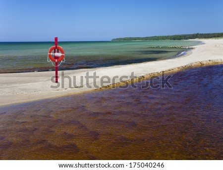 Life bouy, life belt hanging on post. Sandy beach in VÃ?Â?Ã?Â¤Ã?Â?Ã?Â¤na-JÃ?Â?Ã?Âµesuu river mouth in Estonia. Baltic sea.