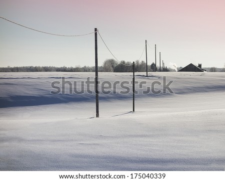 Row of wooden electric poles on empty hilly snow covered landscape. Electrical industry, power line, wiring.
