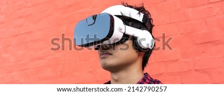Horizontal banner or header with portrait of young oriental man using 3d viewer with headphones outdoor - Metaverse, fictional world and virtual reality concept Stock foto © 