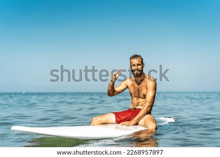 Similar – Image, Stock Photo Surfer friends at the beach with surfboards taking selfie with mobile phone