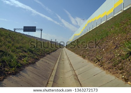 A ditch draining the highway. Wall from sound absorbing panels. ストックフォト © 