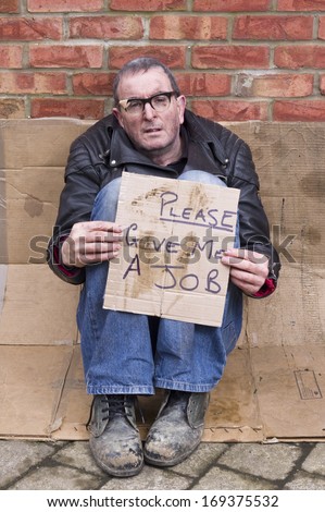 Homeless and Jobless Man Image of a homeless man with a sign asking for a job.