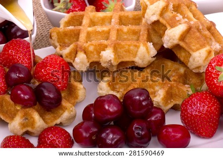Belgian Waffles,  Summer Fruit and Maple Syrup\
A pile of Belgian Waffles and fresh summer fruits with maple syrup drizzled on.
