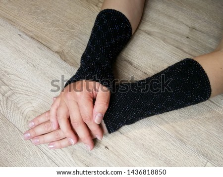 Black fashionable wool knitted wrist warmers on the woman hands Imagine de stoc © 