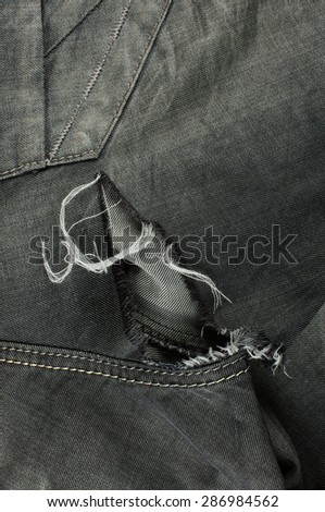 Close up detail of black jeans with tears