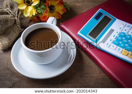Cup of coffee, books and caculator on table wood