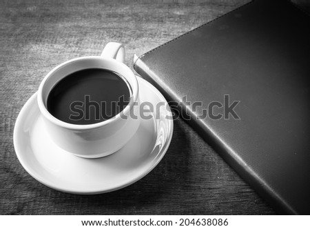 Cup of coffee, books, on table wood