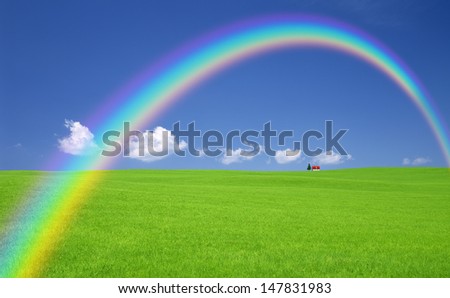 Green grass and red roof house and rainbow