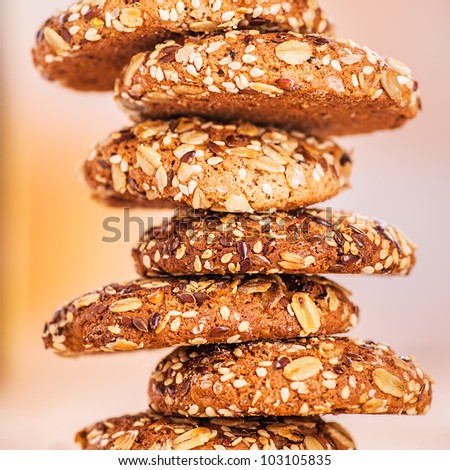 delicious oatmeal cookies with splash of sunflower seeds, sesame seeds on wooden table laid out in row