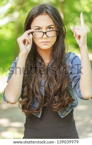 beautiful young woman long dark hair wearing glasses severe frown points finger up