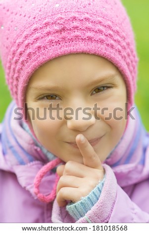 Girl-preschooler in blue jacket, put finger to his lips.