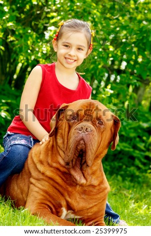 The smiling girl astride the big dog of breed FRENCH MASTIFF, DOGUE DE BORDEAUX