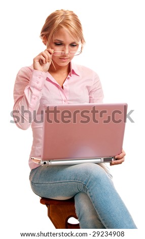 Beautiful blonde in pink shirt works behind pink laptop.