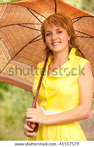 Beautiful smiling girl with sun-protection umbrella against summer nature.