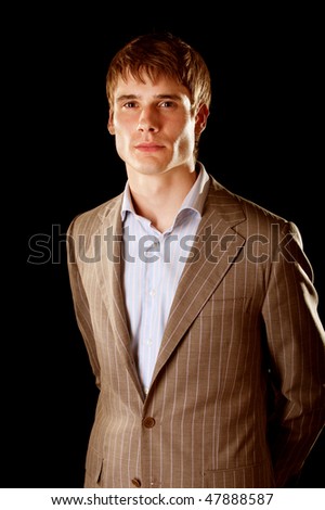 Mature businessman looking at camera with confidence, isolated on black background.