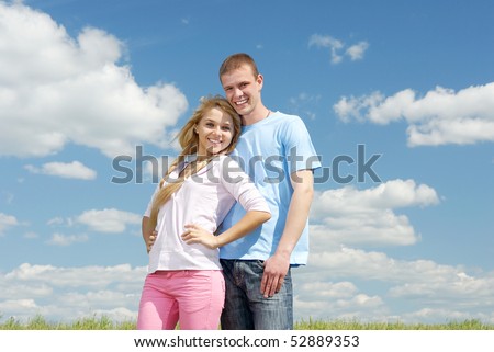 Young beautiful young men laugh against the dark blue sky with clouds