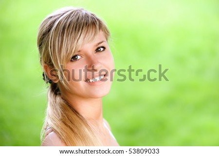 Portrait of smiling young woman close up on green background.