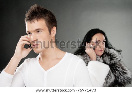 Family couple speak on mobile phones, on gray background.
