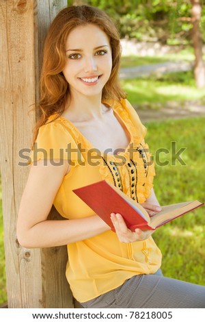 Charming long-haired girl-student reads red book