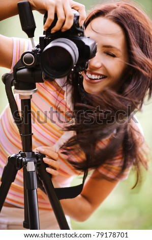 Beautiful smiling girl with camera on nature.