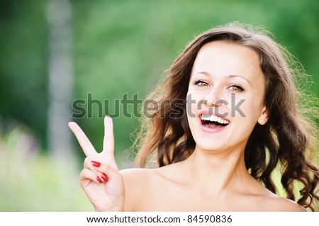 Portrait of young pretty laughing brunette woman showing \