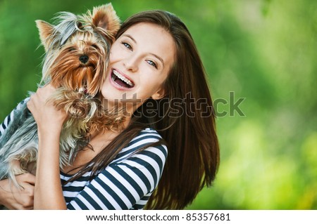 woman beautiful young happy with long dark hair in striped sweater holding small dog