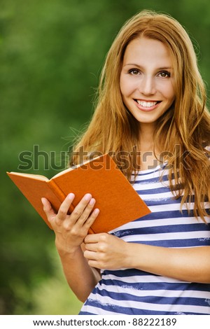 portrait beautiful brown- hair woman holding hands book reading background summer green nature