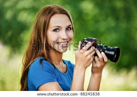 portrait beautiful young woman smiling holding camera background summer green park