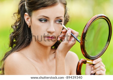 portrait charming young woman bare shoulders looks mirror imposes shadow background nature