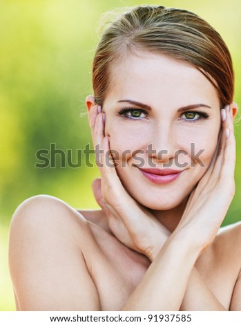 portrait young beautiful woman bare shoulders holding palm cheeks background summer green park