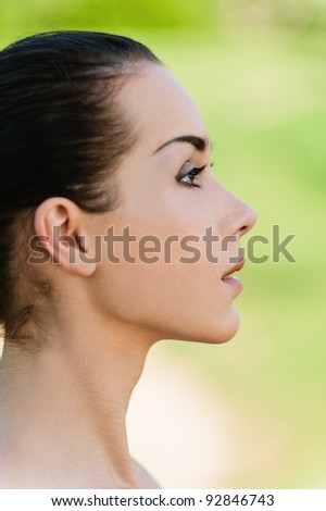 Portrait of beautiful girl in profile, on green background.