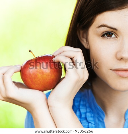 portrait half of face young sad pretty woman holds red apple hands background summer green park
