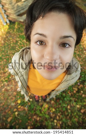 Beautiful dark-haired woman on earth covered with autumn fallen leaves.