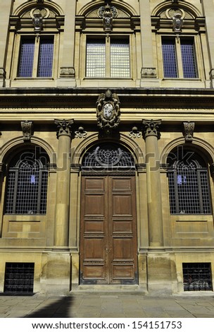 Ornate stone facade of large wooden door and windows in Oxford UK