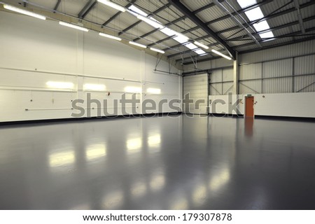 interior of empty and new warehouse with doors, grey newly painted floor