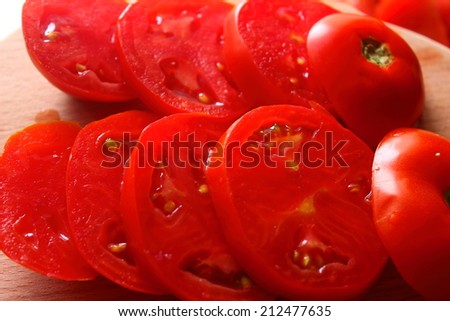on the table on the board are fresh tomatoes, cut into rings