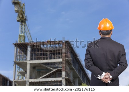 engineer holding orange helmet for workers security on contruction background