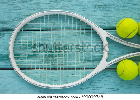 tennis racket with tennis ball on green wood texture