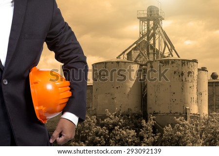 engineer holding orange helmet for workers security on contruction background