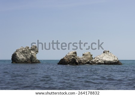 Four figured rocks in the sea under clear blue sky without clouds and sun. View from the coast, nobody around. Black Sea, Crimea, Ukraine