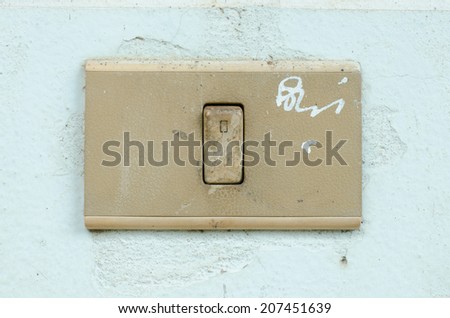 Old dirty switch on the white wall.