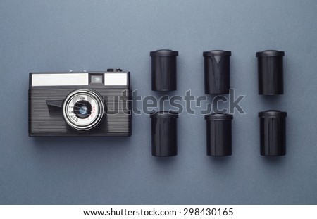Vintage Photo Camera and photo film rolls well organized over dark blue background, above view