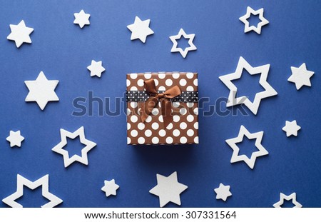 Christmas Gift Box and white stars over dark blue background, above view