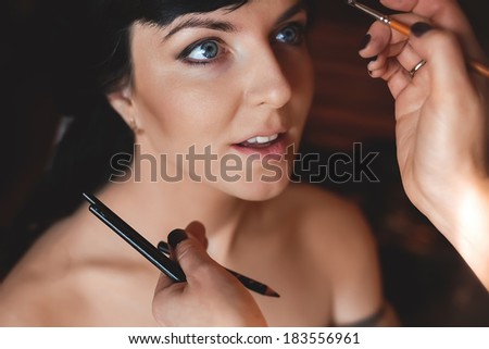 make up artist applying makeup on bride