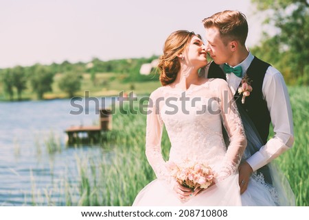 kissing married couple near pond