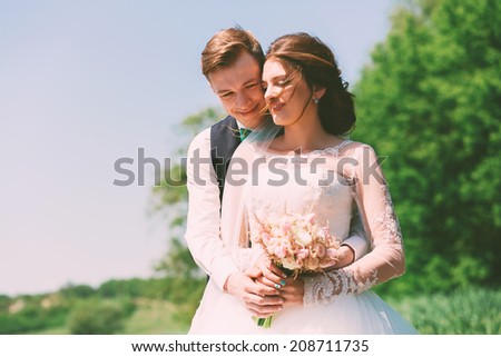 bride and groom smiling on nature