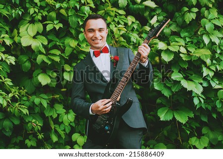 cheerful groom playing the guitar