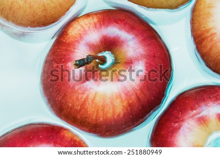 juicy big red apple in cold blue water